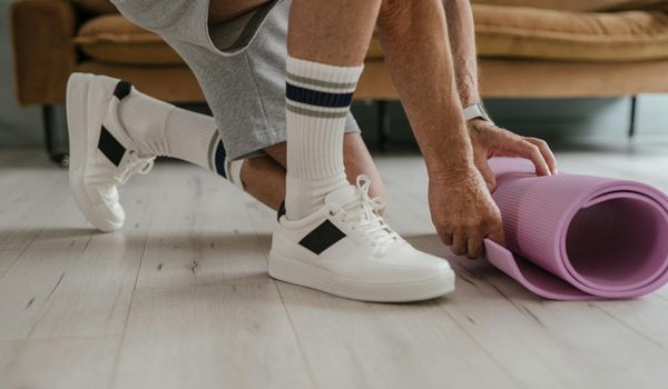 Close-up of a person stretching in a well-lit studio.